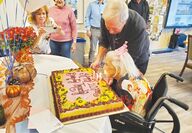 107 year old Trudy Newton blows out candles on her cake.