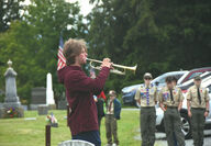 A bugler plays at a Memorial Day cemetery ceremony