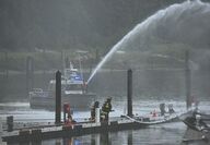A fire boat shoots a stream of water at a dock
