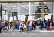 Strikers picket in front of a building