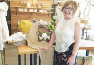 A woman shows items for sale in her store