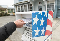 Hand putting ballot in dropbox.