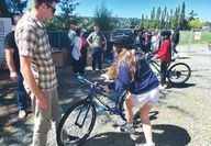 A man helps children with their new bikes